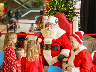 Santa speaking with a group of children.