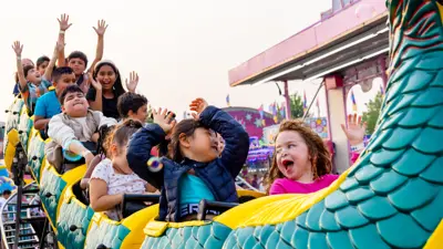 Children riding a roller coaster.