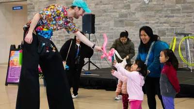 Child receiving a balloon animal.