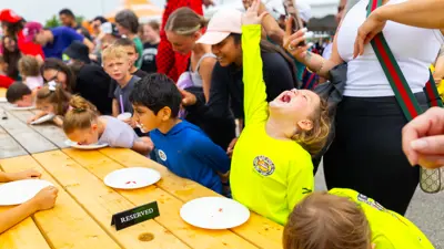 Children participating in a strawberry eating contest.